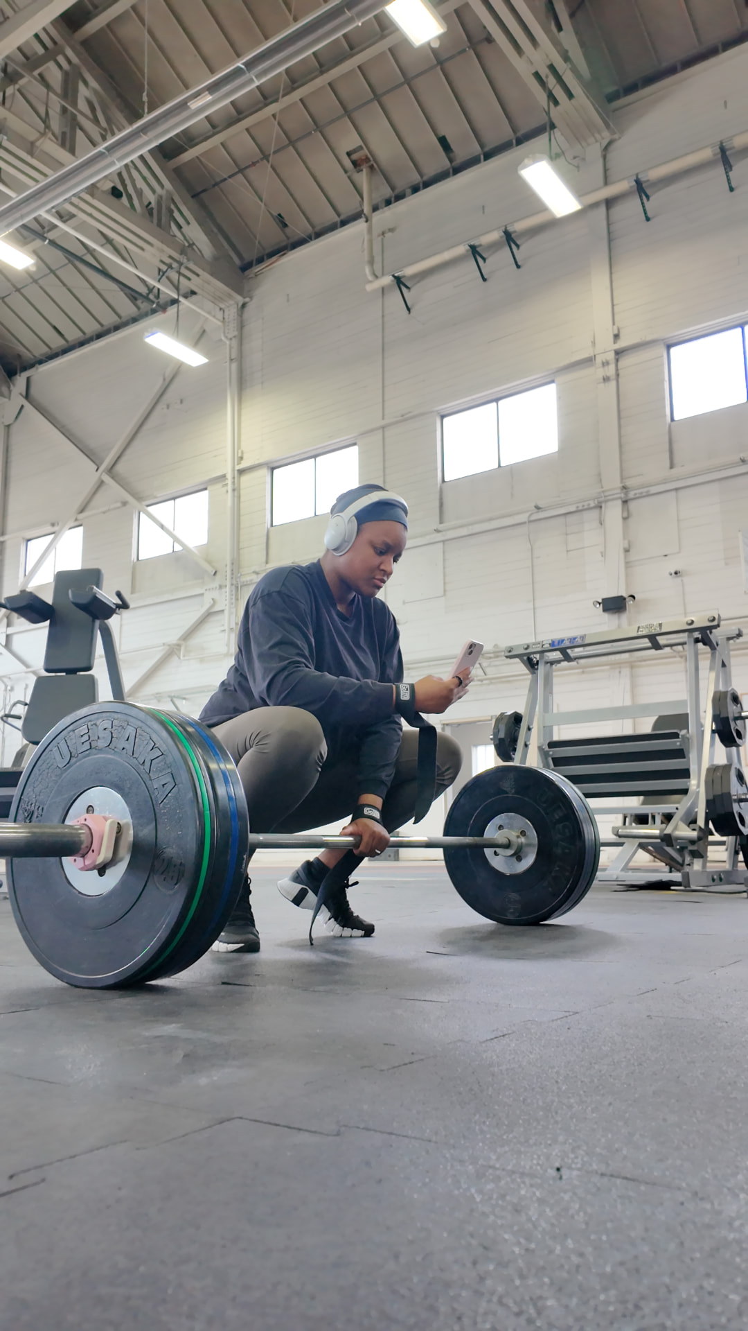 Athlete setting up for a barbell lift with bumper plates loaded in the gym